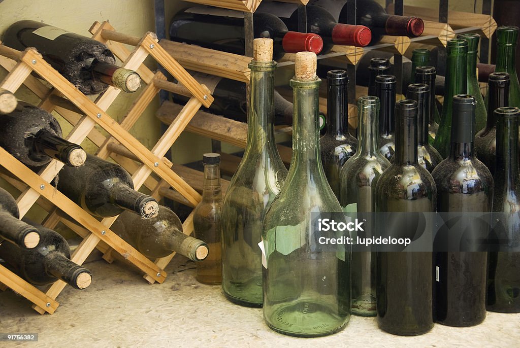 Wein in Flaschen, alte und neue liegen unter den clutter - Lizenzfrei Flaschenregal Stock-Foto