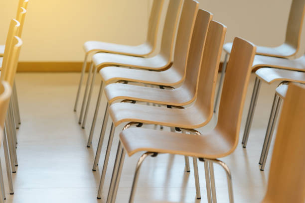 istock Many empty wooden chairs set neat rows in conference room 917565936