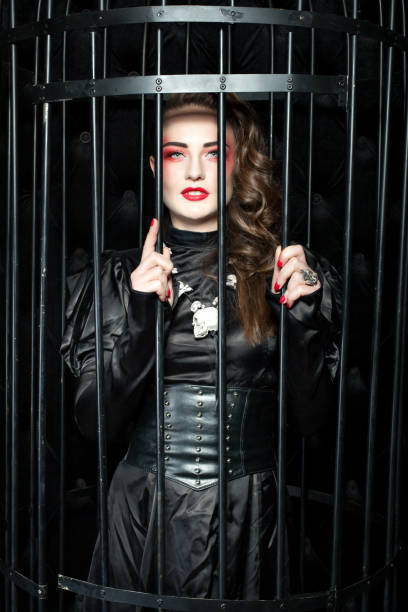 istock Woman is standing in a black cage. 917574622
