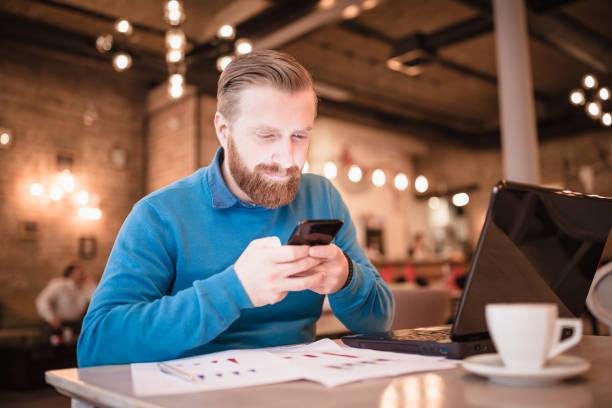 istock Young, redhead businessman, on coffee break working using laptop 917586906