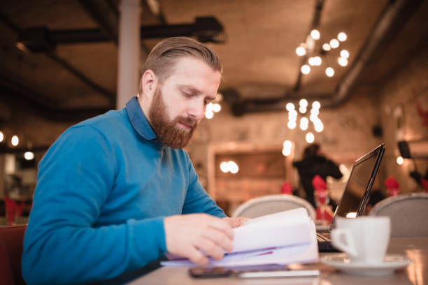istock Young, redhead businessman, on coffee break working using laptop 917586914