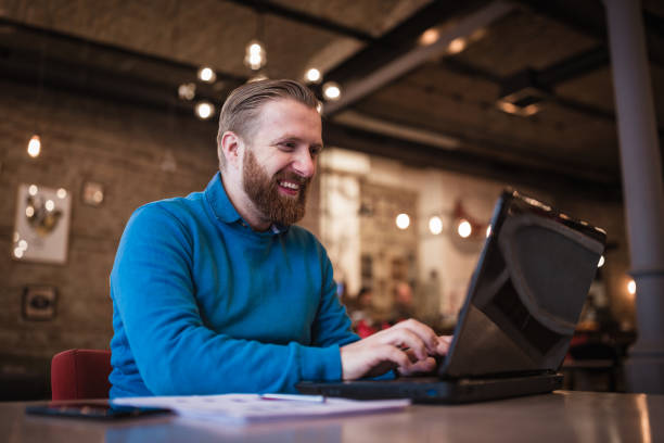 istock Young, redhead businessman, on coffee break working using laptop 917587226