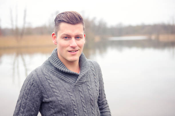portrait of handsome blond man in front of lake