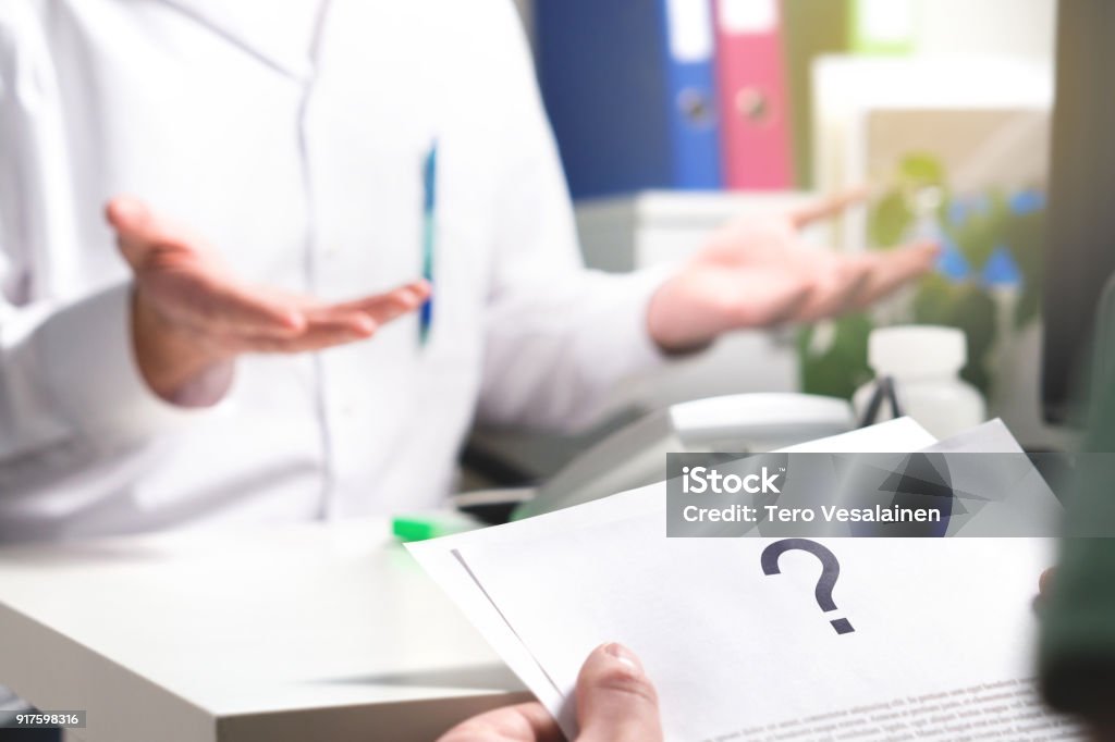 Medical problem. Patient reading health care document with question mark. New or unknown disease. Can't find or no cure for illness. Wrong diagnosis. Medical problem. Patient reading health care document with question mark. New or unknown disease. Can't find or no cure for illness. Wrong diagnosis. Clueless doctor spreading hands. Doctor Stock Photo