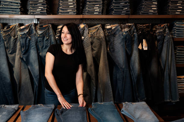 istock jeans store, woman shop assistant at work 917598852