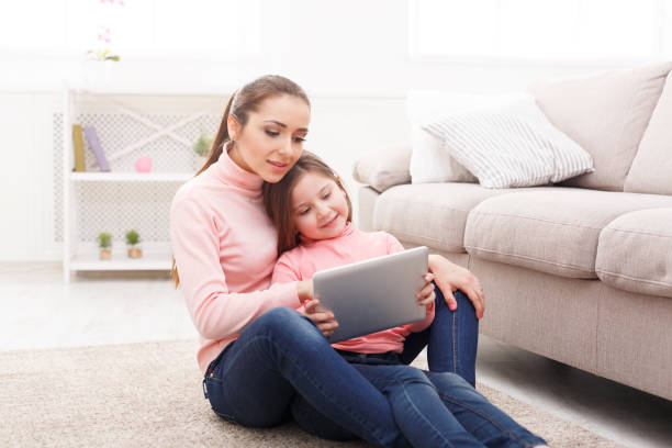 istock Little girl and her mom using a tablet at home 917605988