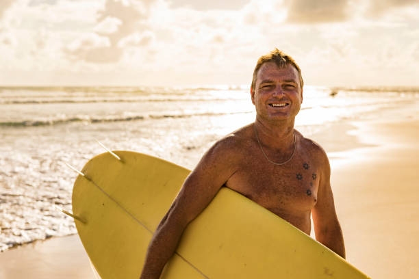 istock Man About to go Surfing at the Beach 917606220