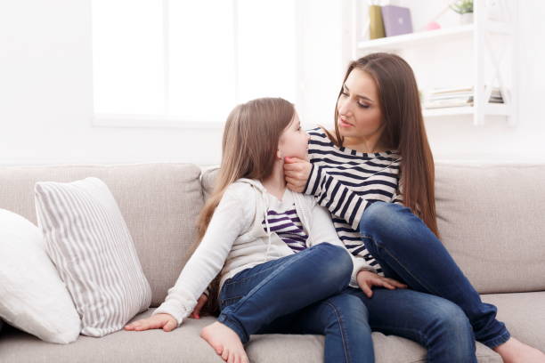istock Mother with her cute little daughter sitting on the sofa. 917606834