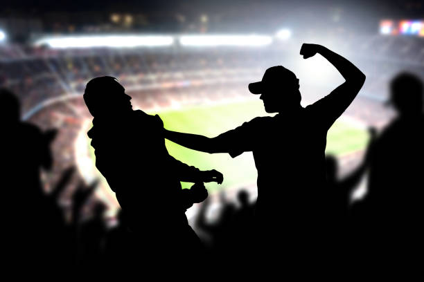 fight in a football game crowd. angry man hitting another spectator in soccer match audience. violent argument between two fans of different teams and clubs. - people in a row imagens e fotografias de stock