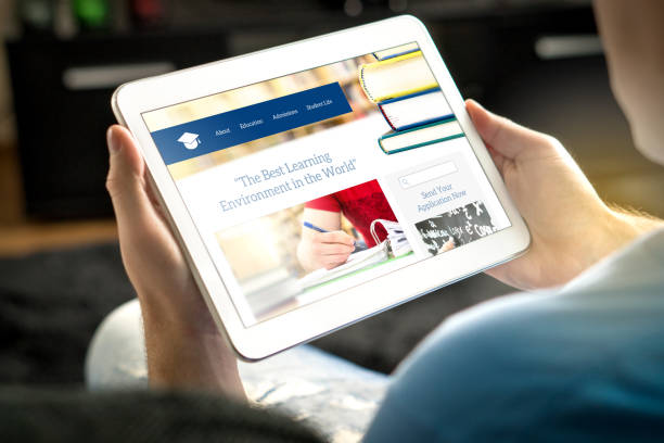 istock School website on tablet screen. Young man and applicant browsing college or university websites before applying. 917612040