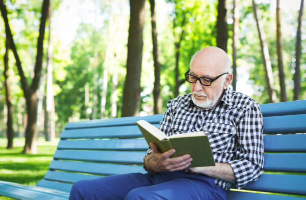 istock Elderly man in casual reading outdoors 917612092