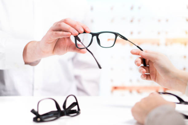 istock Optician giving new glasses to customer for testing and trying. 917614208