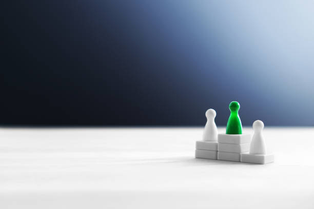 istock Winning, victory, being the best, success and domination concept. Winner standing on podium. Reaching goals. Outstanding performance by one different color board game pawn. 917618114