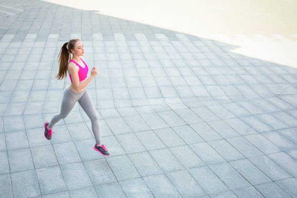 istock Young woman running in city copy space 917618140