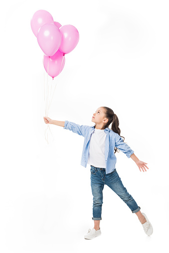 adorable little kid looking at pink balloons in hand isolated on white