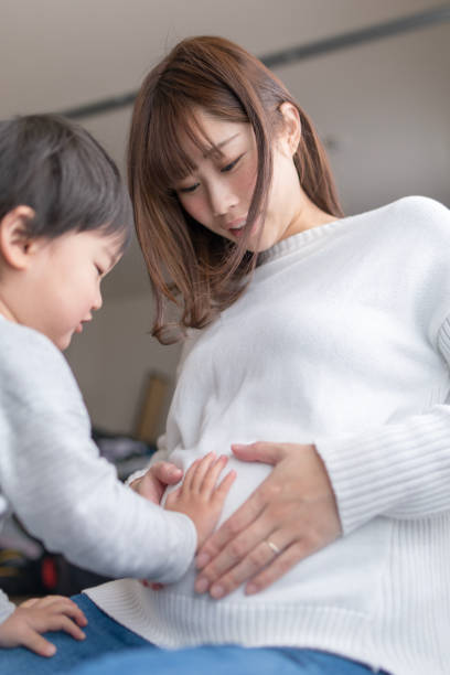 istock Little boy touching  pregnant mother's abdomen 917626196