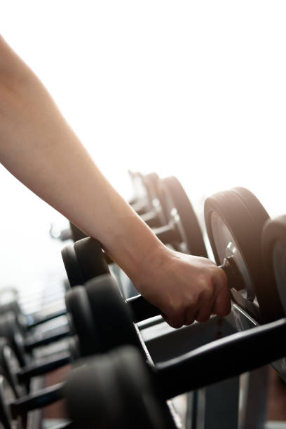 istock human's hand, taking dumbbell in gym 917627272