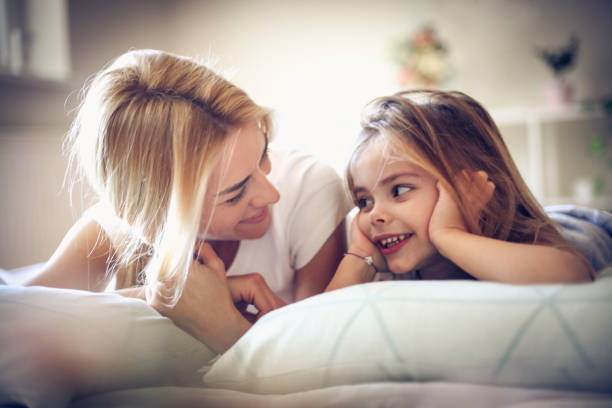 istock Mother and daughter lying on a bed, morning time. 917630646