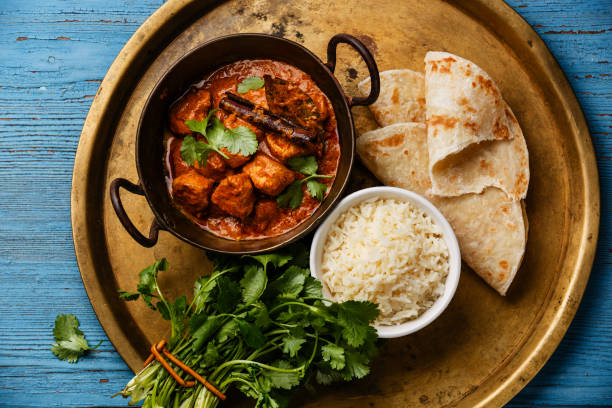 Chicken tikka masala spicy curry meat food Chicken tikka masala spicy curry meat food with rice and naan bread on copper tray close-up indian food stock pictures, royalty-free photos & images