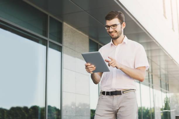 istock Smiling businessman working with tablet outdoors 917634344
