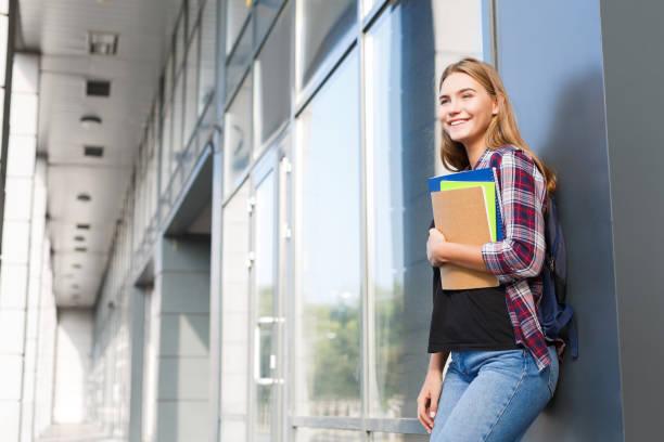 istock Student girl with books on university background 917634668