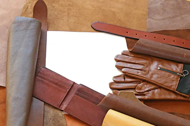 Accessories of genuine leather-gloves, belt, purse and pieces of natural leather on a white background.Leather frame