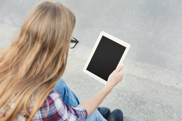 istock Happy young woman using digital tablet outdoors 917637988