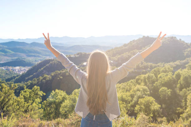 istock Beautiful women showing peace sign while enjoying mountains landscape 917638496