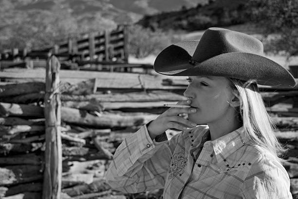 Smoking cowgirl stock photo