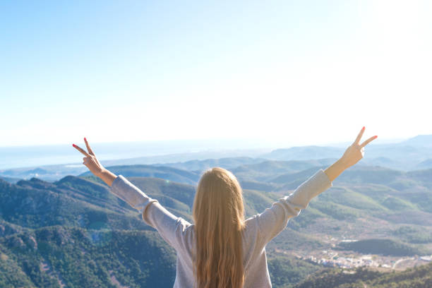 istock Beautiful women showing peace sign while enjoying mountains landscape 917641220