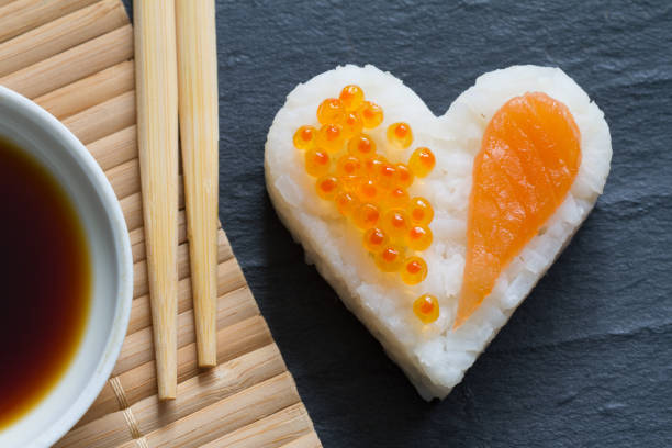 Sushi heart macro seafood concept with salmon and caviar on black background