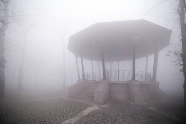 Gazebo in heavy fog at dawn in a park