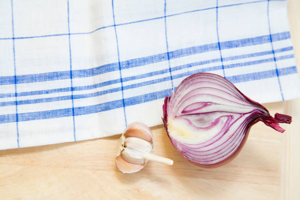 Set of raw ingredients for Italian cooking on a tablecloth background. Onion and garlic. Set of healthy food products. Closeup