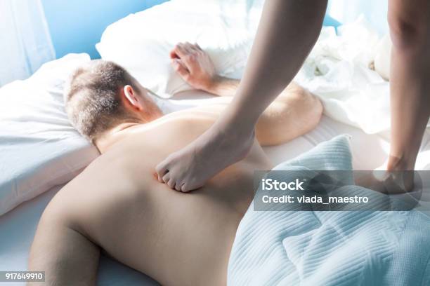 Young Woman Massage Her Husband In Bed Stock Photo - Download Image Now - 20-29 Years, 25-29 Years, Adult