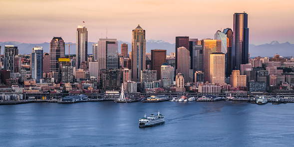 View of crowded modern cityscape with 1201 Third Avenue, U.S. Bank Centre, ship moving in foreground, Seattle, Washington, United States.