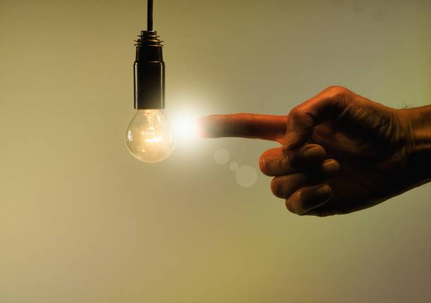 istock Male hand indicates light bulb light on sepia background. Creative gesture concept. 917653020