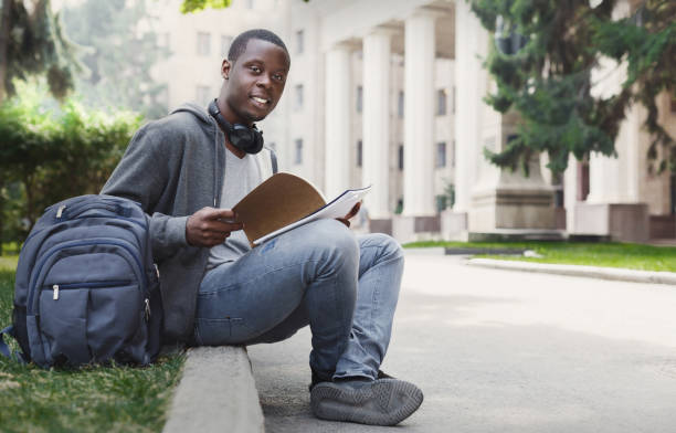 istock African-american student sitting with notebook in university campus 917659516