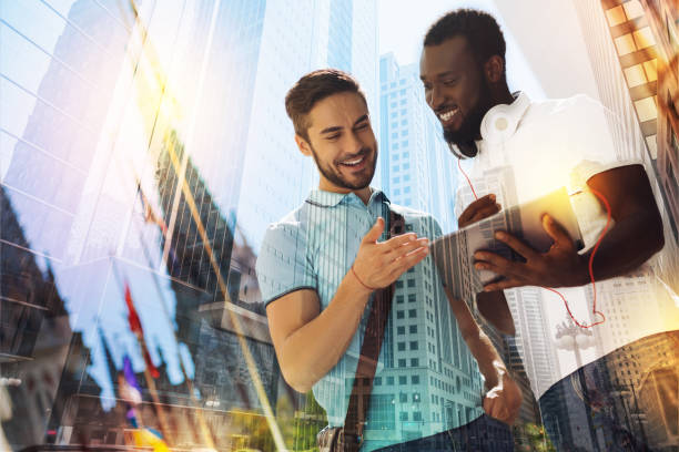 istock Emotional students smiling while looking at the screen of a tablet 917659616
