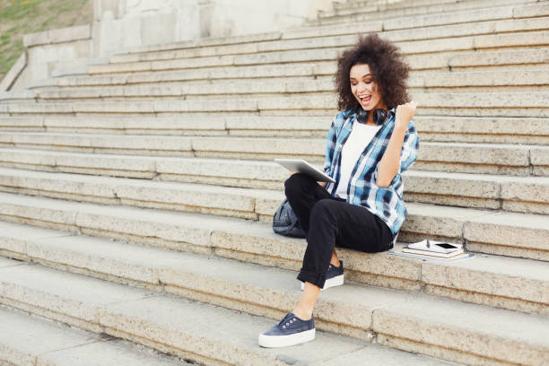 istock Happy young woman using digital tablet outdoors 917661192