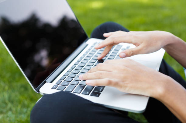 istock Happy young woman using laptop outdoors 917663986