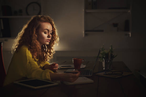 istock Concentrated woman making notes at home in the evening 917664060