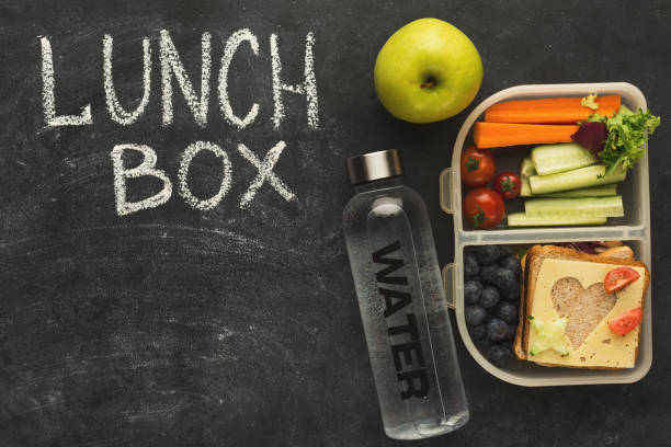 istock Lunch boxes filled with healthy food on black board 917669004