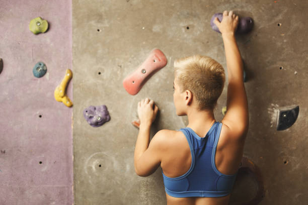istock Young woman climbing artificial rock wall at gym 917669892