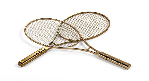 Two gold tennis rackets stock photo