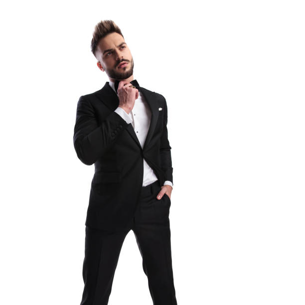 istock relaxed elegant man in tuxedo fixing his bowtie 917676744