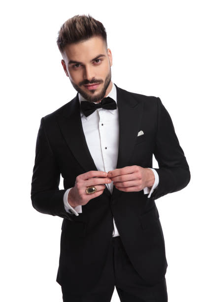 istock smiling elegant man in tuxedo touching his fingers and posing 917677528