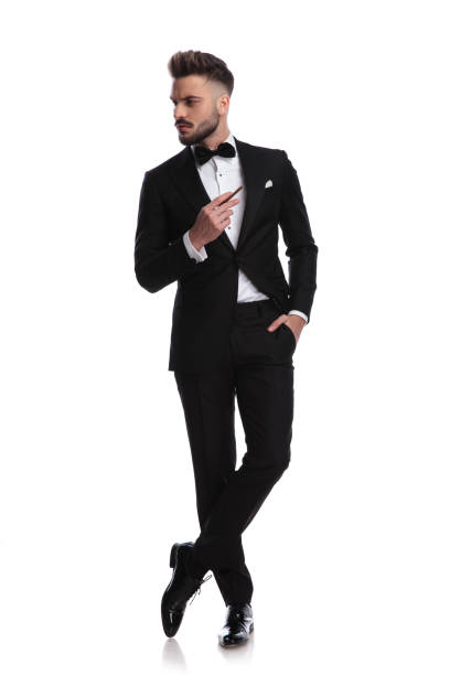 istock cool man in tuxedo is smoking and looks to side 917678720