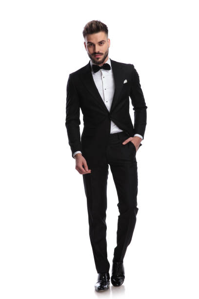 istock smiling man in tuxedo stands with one hand in pocket 917683134