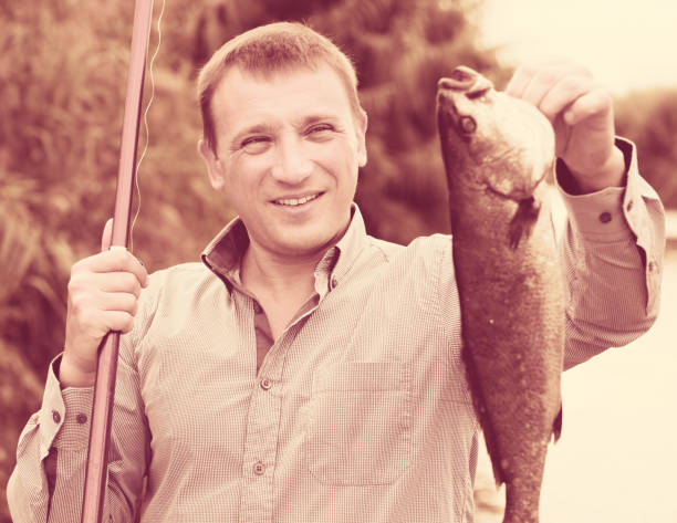 istock Man holding fish after fishing 917685334