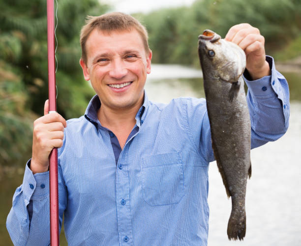 istock Man holding fish after fishing 917685388